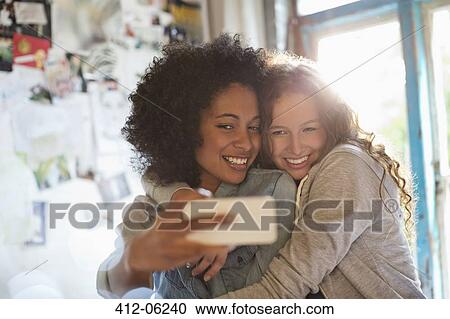 Women taking picture together in bedroom View Large Photo Image Stock Image - Women taking picture together in bedroom. Fotosearch
