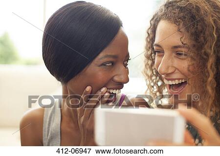 Women using cell phone on sofa View Large Photo Image Stock Photo - Women using cell phone on sofa. Fotosearch