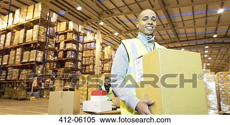 Worker carrying box in warehouse View Large Photo Image Stock Photography - Worker carrying box in warehouse. Fotosearch
