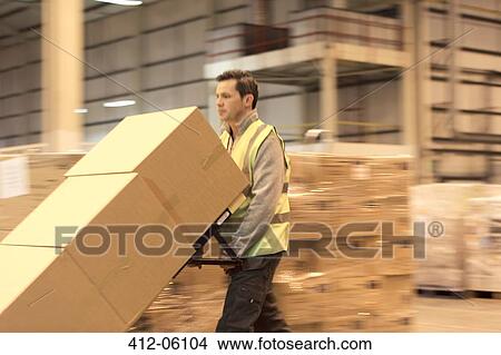 Worker carting boxes in warehouse View Large Photo Image Picture - Worker carting boxes in warehouse. Fotosearch