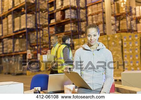 Worker holding clipboard in warehouse View Large Photo Image Stock Photo - Worker holding clipboard in warehouse. Fotosearch