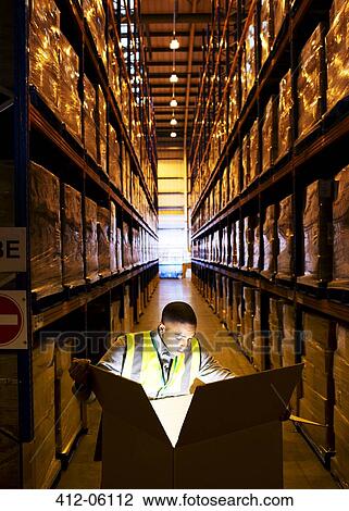 Worker opening glowing box in warehouse View Large Photo Image Stock Image - Worker opening glowing box in warehouse. Fotosearch