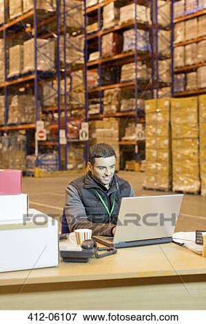 Worker using laptop in warehouse View Large Photo Image Stock Photo - Worker using laptop in warehouse. Fotosearch