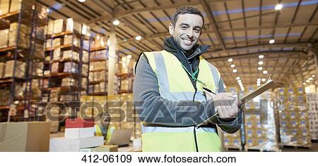 Worker writing on clipboard in warehouse View Large Photo Image Stock Photo - Worker writing on clipboard in warehouse. Fotosearch
