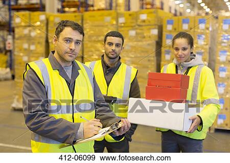 Workers standing in warehouse View Large Photo Image Stock Photo - Workers standing in warehouse. Fotosearch