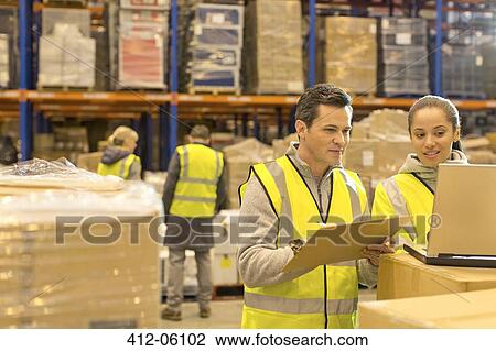 Workers using laptop in warehouse View Large Photo Image Stock Image - Workers using laptop in warehouse. Fotosearch