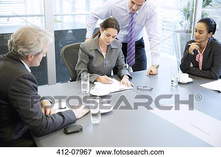 Business people reviewing paperwork in meeting View Large Photo Image Stock Photo - Business people reviewing paperwork in meeting. Fotosearch