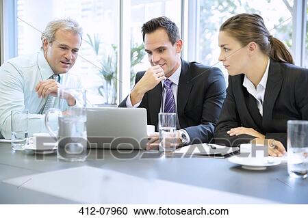 Business people sharing laptop in meeting View Large Photo Image Stock Image - Business people sharing laptop in meeting. Fotosearch