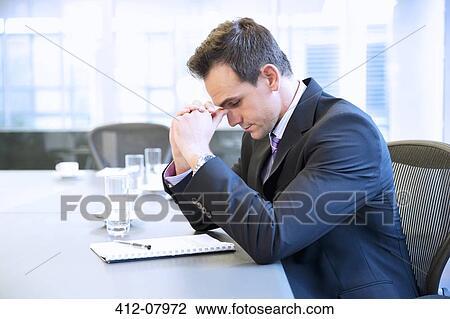 Businessman with head in hands in conference room View Large Photo Image Stock Image - Businessman with head in hands in conference room. Fotosearch