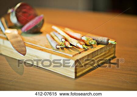 Close up of carrots on cutting board View Large Photo Image Stock Photography - Close up of carrots on cutting board. Fotosearch