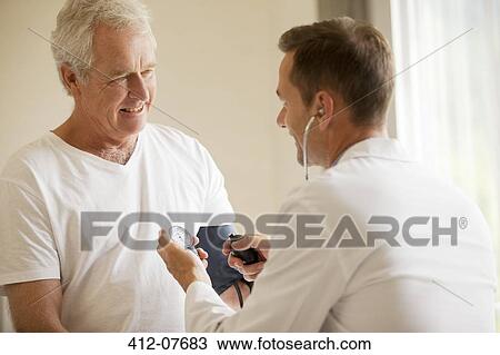 Doctor checking senior man's blood pressure in doctor's office View Large Photo Image Stock Image - Doctor checking senior man's blood pressure in doctor's office. Fotosearch