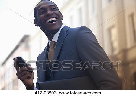 Enthusiastic businessman text messaging with cell phone View Large Photo Image Stock Image - Enthusiastic businessman text messaging with cell phone. Fotosearch