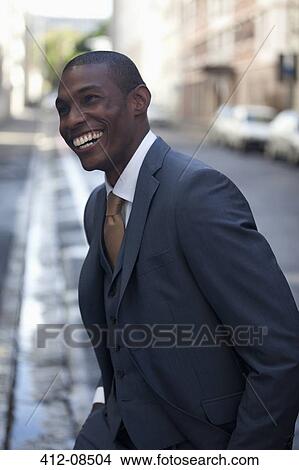 Happy businessman walking in street View Large Photo Image Picture - Happy businessman walking in street. Fotosearch