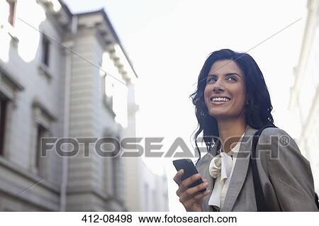 Happy businesswoman text messaging with cell phone View Large Photo Image Stock Photo - Happy businesswoman text messaging with cell phone. Fotosearch