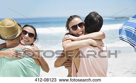 Happy couples hugging at beach View Large Photo Image Stock Image - Happy couples hugging at beach. Fotosearch