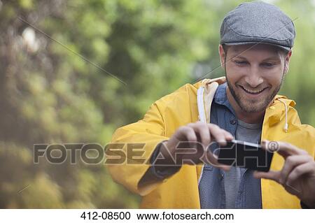 Happy man taking photograph with camera phone View Large Photo Image Stock Image - Happy man taking photograph with camera phone. Fotosearch