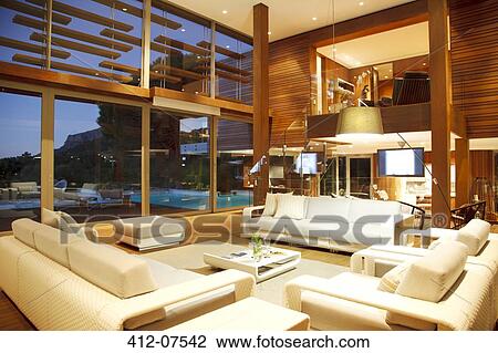 Illuminated modern living room at night View Large Photo Image Stock Image - Illuminated modern living room at night. Fotosearch