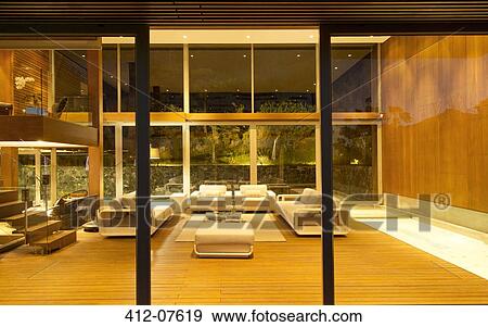 Illuminated modern living room at night View Large Photo Image Stock Photo - Illuminated modern living room at night. Fotosearch