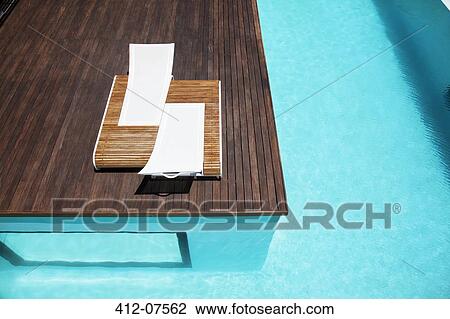 Stock Image - Lounge chairs and swimming pool. Fotosearch