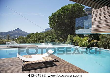 Stock Image - Luxury swimming pool with mountain view. Fotosearch