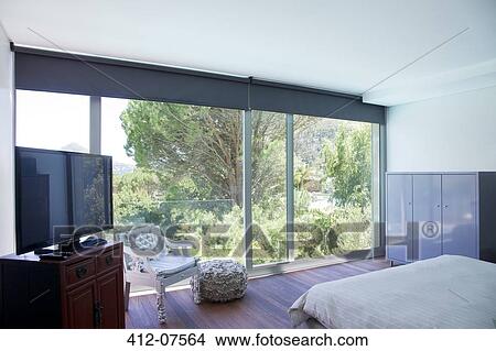 Modern bedroom with glass sliding doors View Large Photo Image Picture - Modern bedroom with glass sliding doors. Fotosearch