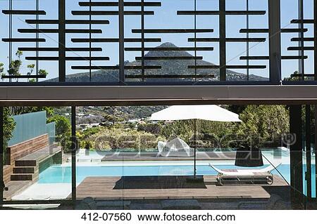 Modern house with view of swimming pool View Large Photo Image Stock Image - Modern house with view of swimming pool. Fotosearch