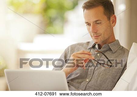 Pensive man using laptop View Large Photo Image Stock Image - Pensive man using laptop. Fotosearch