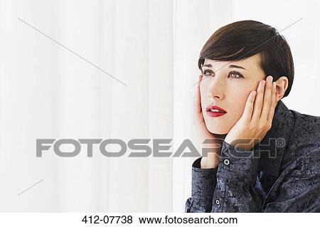 Pensive woman with head in hands looking out window View Large Photo Image Stock Photo - Pensive woman with head in hands looking out window. Fotosearch