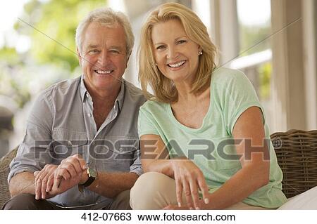 Stock Image - Portrait of smiling couple on patio. Fotosearch