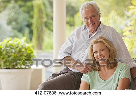 Stock Photograph - Portrait of smiling couple on porch. Fotosearch