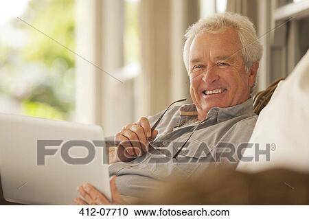 Portrait of smiling senior man using laptop on porch View Large Photo Image Stock Image - Portrait of smiling senior man using laptop on porch. Fotosearch
