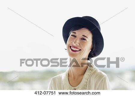 Stock Image - Portrait of smiling woman wearing hat. Fotosearch