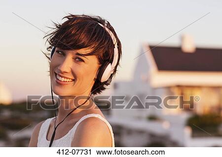 Stock Image - Portrait of smiling woman wearing headphones. Fotosearch