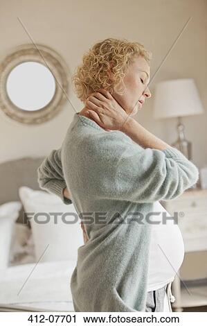 Pregnant woman holding neck and back in pain View Large Photo Image Stock Image - Pregnant woman holding neck and back in pain. Fotosearch