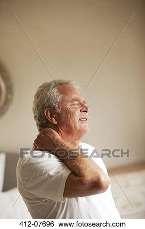Stock Photograph - Senior man holding neck in pain. Fotosearch