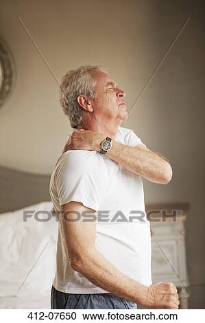 Stock Image - Senior man holding shoulder in pain. Fotosearch