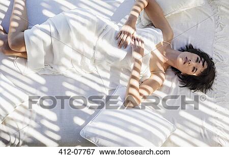 Stock Photo - Serene woman laying in bed. Fotosearch