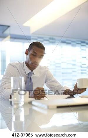 Serious businessman reading paperwork View Large Photo Image Stock Photography - Serious businessman reading paperwork. Fotosearch