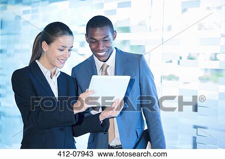 Smiling businessman and businesswoman using digital tablet View Large Photo Image Stock Image - Smiling businessman and businesswoman using digital tablet. Fotosearch