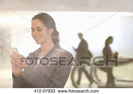 Smiling businesswoman text messaging with cell phone View Large Photo Image Stock Image - Smiling businesswoman text messaging with cell phone. Fotosearch