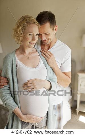 Smiling man hugging pregnant woman View Large Photo Image Stock Image - Smiling man hugging pregnant woman. Fotosearch
