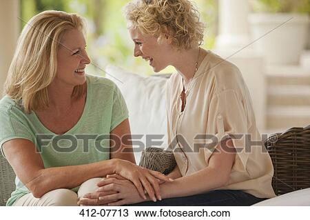 Smiling mother and daughter holding hands on porch View Large Photo Image Stock Image - Smiling mother and daughter holding hands on porch. Fotosearch
