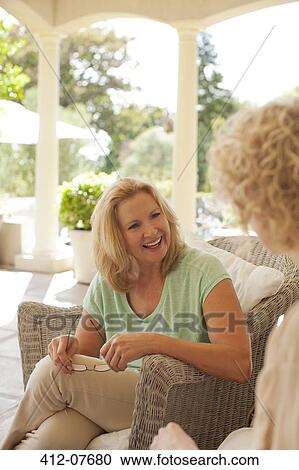 Smiling mother and daughter talking on porch View Large Photo Image Stock Image - Smiling mother and daughter talking on porch. Fotosearch