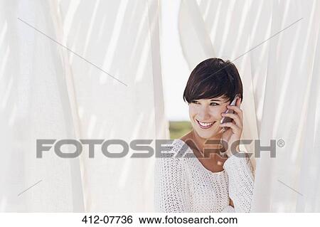 Smiling woman talking on cell phone View Large Photo Image Stock Photograph - Smiling woman talking on cell phone. Fotosearch