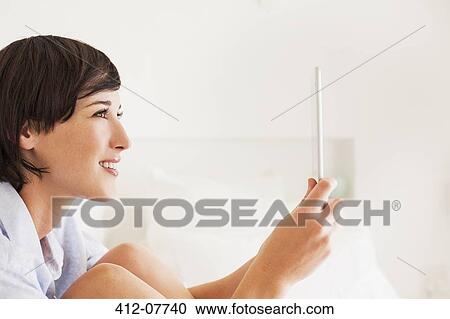 Smiling woman using digital tablet View Large Photo Image Stock Image - Smiling woman using digital tablet. Fotosearch