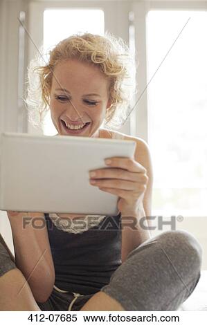 Smiling woman using digital tablet View Large Photo Image Stock Photography - Smiling woman using digital tablet. Fotosearch