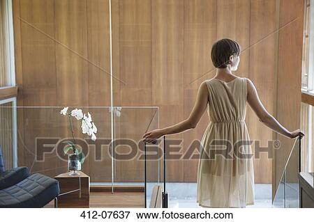 Woman standing at top of stairs in modern house View Large Photo Image Stock Photo - Woman standing at top of stairs in modern house. Fotosearch