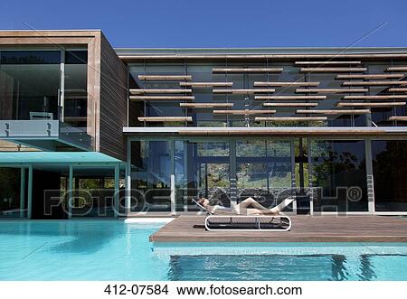 Woman sunbathing on lounge chair at poolside View Large Photo Image Picture - Woman sunbathing on lounge chair at poolside. Fotosearch