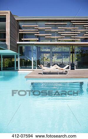 Woman sunbathing on lounge chair at poolside View Large Photo Image Picture - Woman sunbathing on lounge chair at poolside. Fotosearch