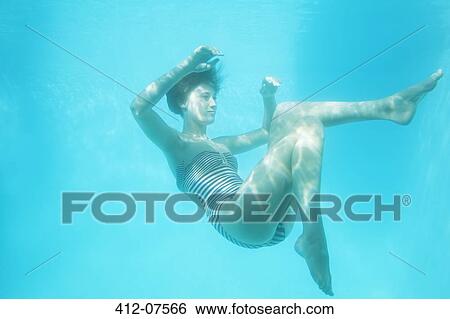 Stock Photograph - Woman swimming underwater. Fotosearch